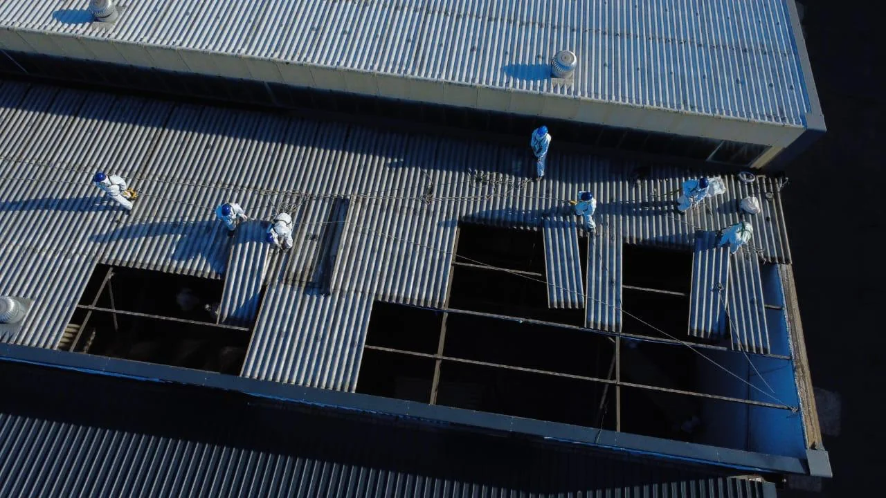 Team at work on a large corrugated industrial roof